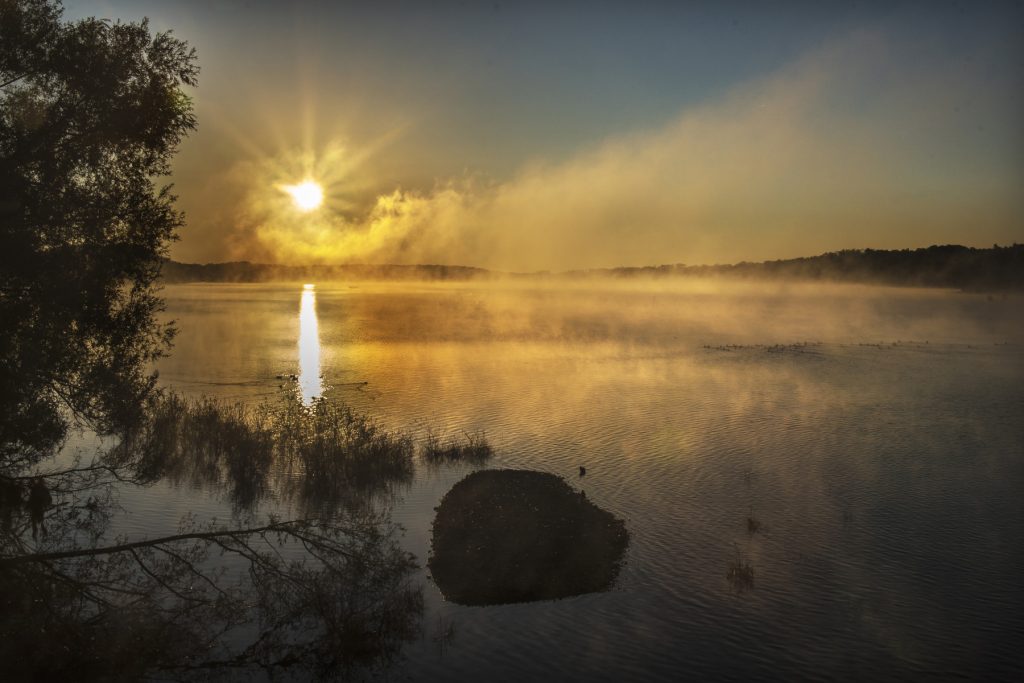 Photo d'un lac avec un début de coucher de soleil reflétant sur le lac - Image Bienvenue